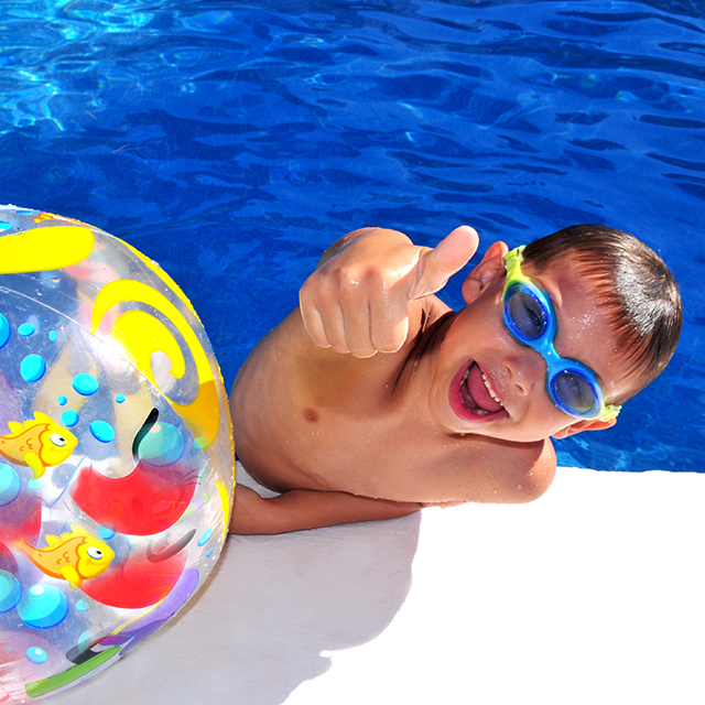 Junge mit Taucherbrille und Wasserball mit Daumen nach oben