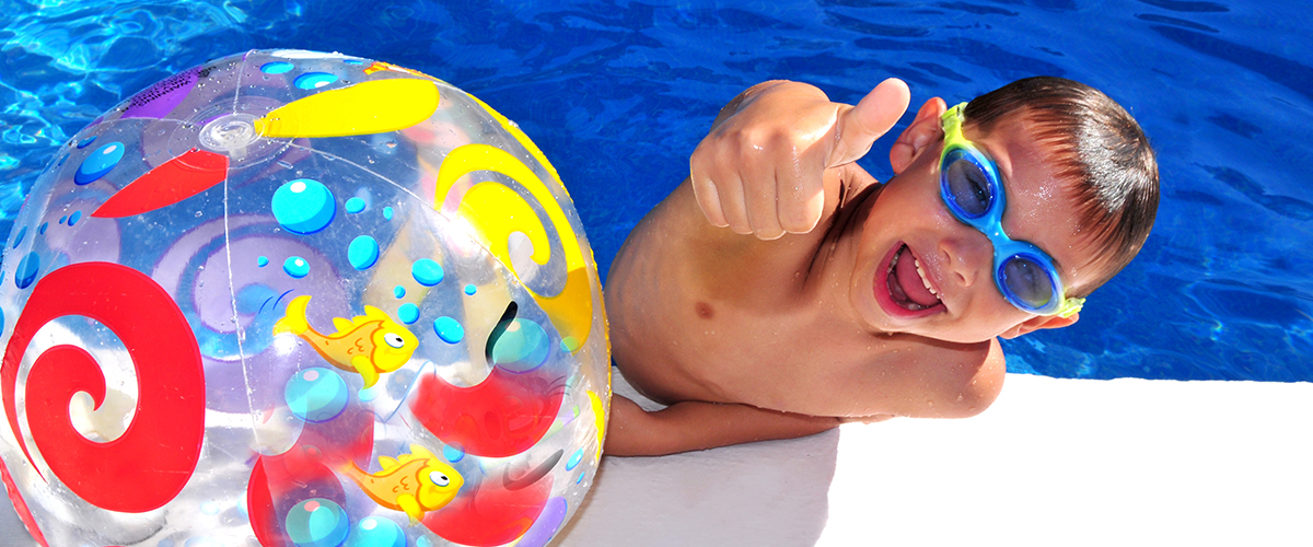 Junge mit Taucherbrille und Wasserball mit Daumen nach oben