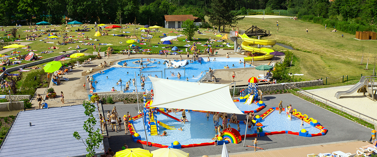 Luftaufnahme vom Außenbereich mit Blick auf Kleinkinderbecken und Außenrutsche