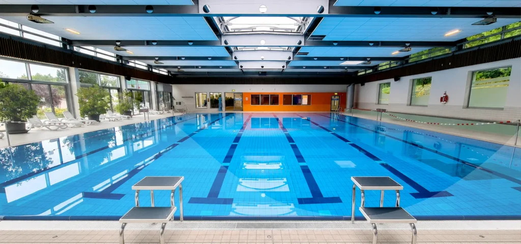 Leeres Schwimmbecken im Innenbereich mit Startblöcken