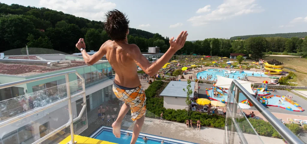 Junger Mann springt vom 10 Meter Sprungturm