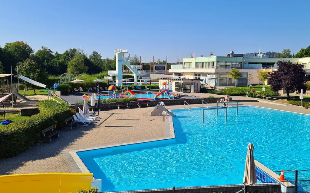 Blick über die verschiedenen Außenbecken, Spielplatz und Kinderbecken