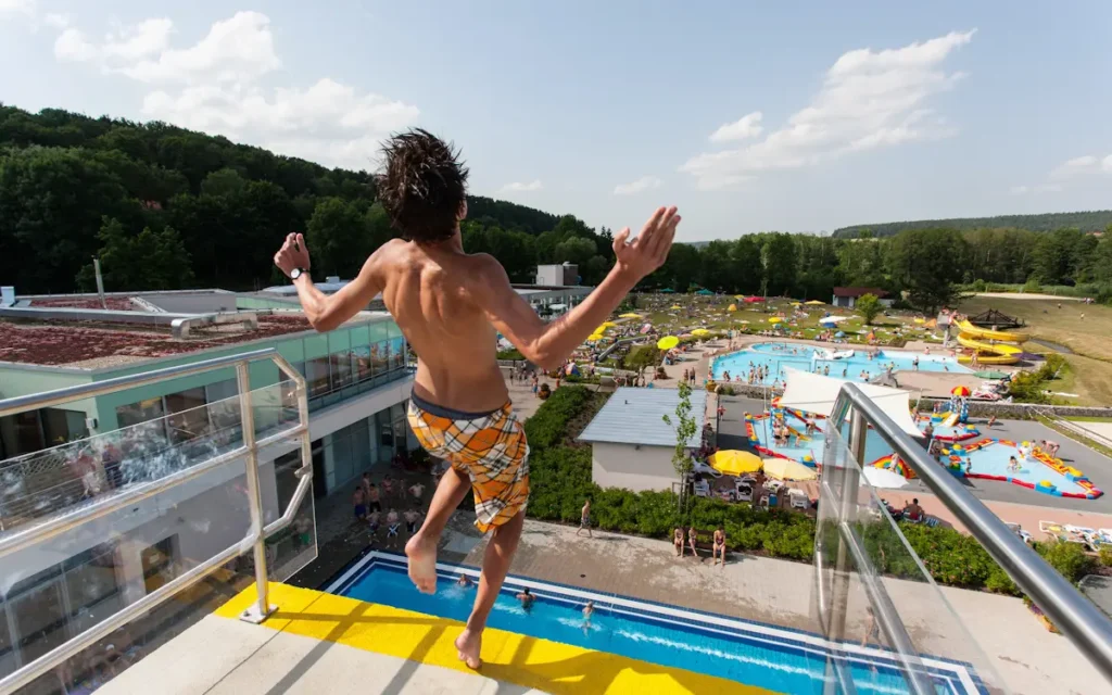 Junger Mann springt vom 10 Meter Sprungturm