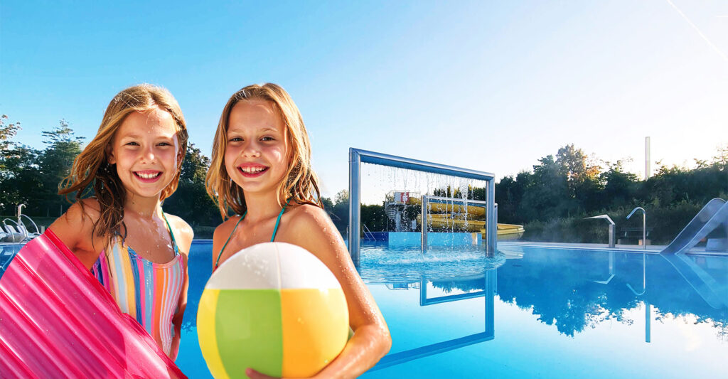 Zwei junge Mädchen in Badebekleidung stehen vor dem Erlebnisbecken im Freibad