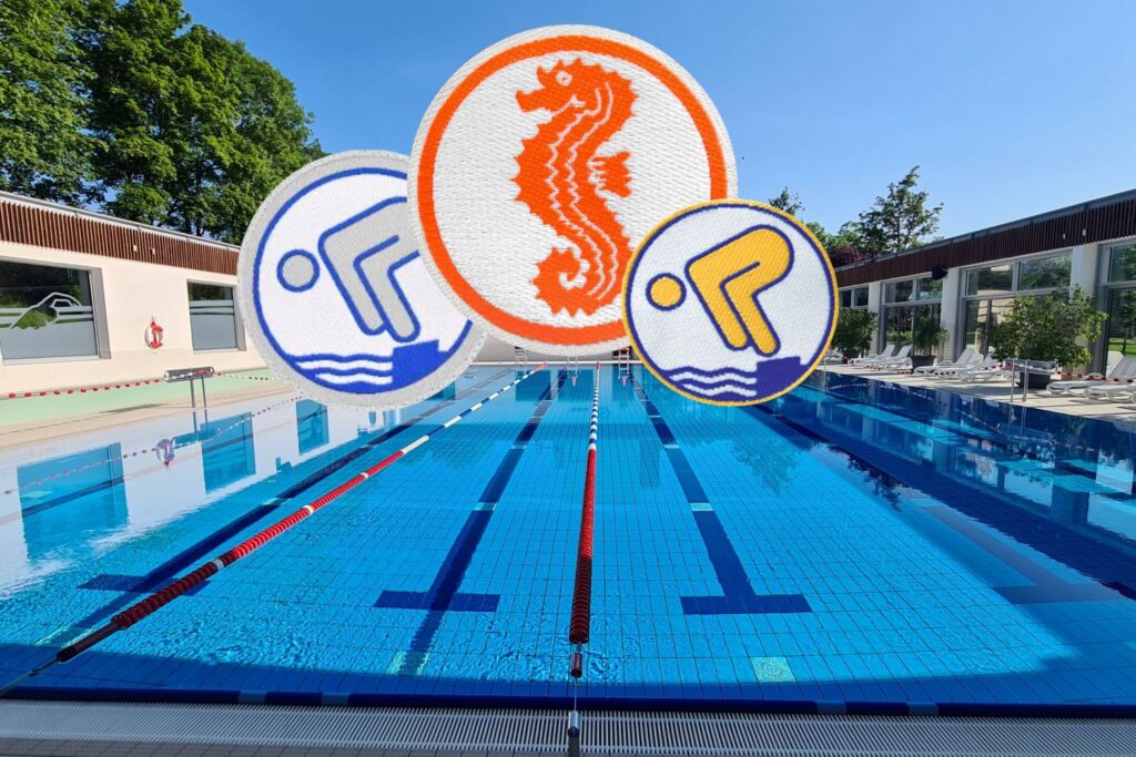 Schwimmbecken mit offenem Dach im Hintergrund und Schwimmabzeichen im Vordergrund
